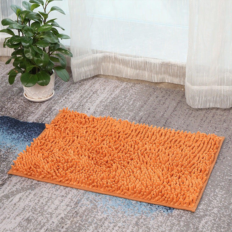 Orange Super Absorbent Door Mat on a carpeted floor with a plant and curtains in the background