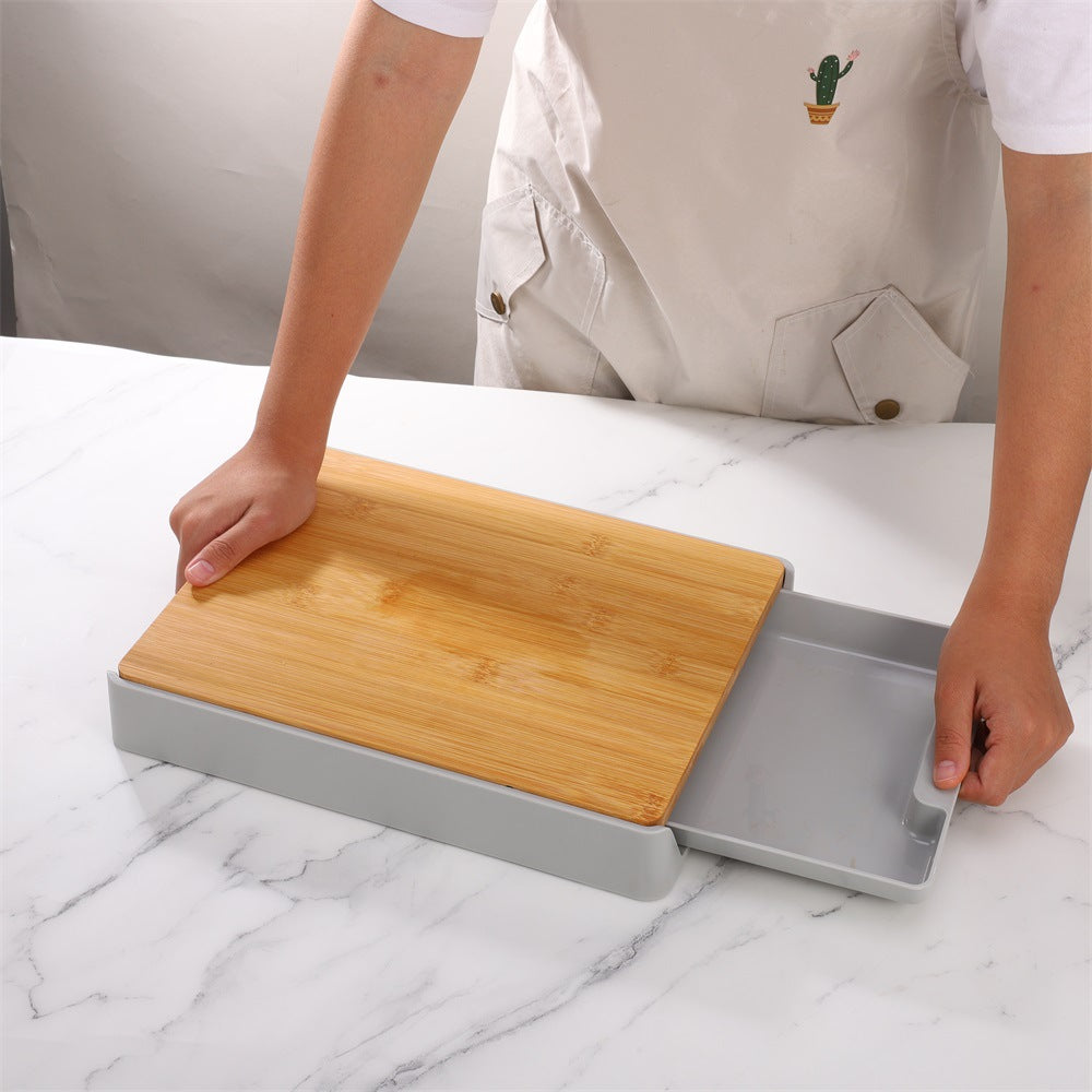 Person using a bamboo cutting board with a gray base on a marble surface