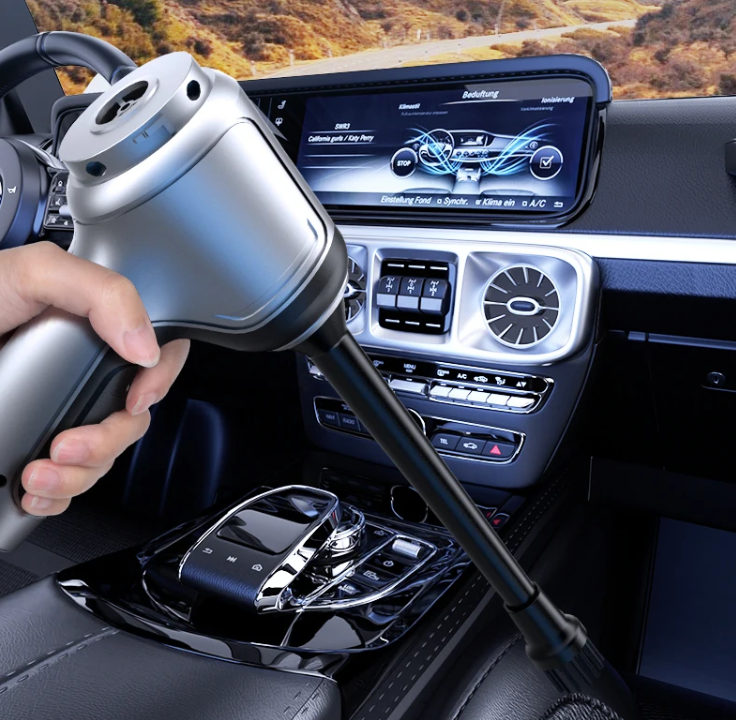 Hand using a Car Wireless Vacuum Cleaner inside a car with a digital display in the background.