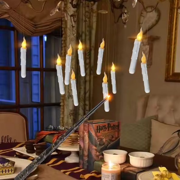 Flickering candles hanging from a chandelier in a cozy room with Harry Potter books and decor.